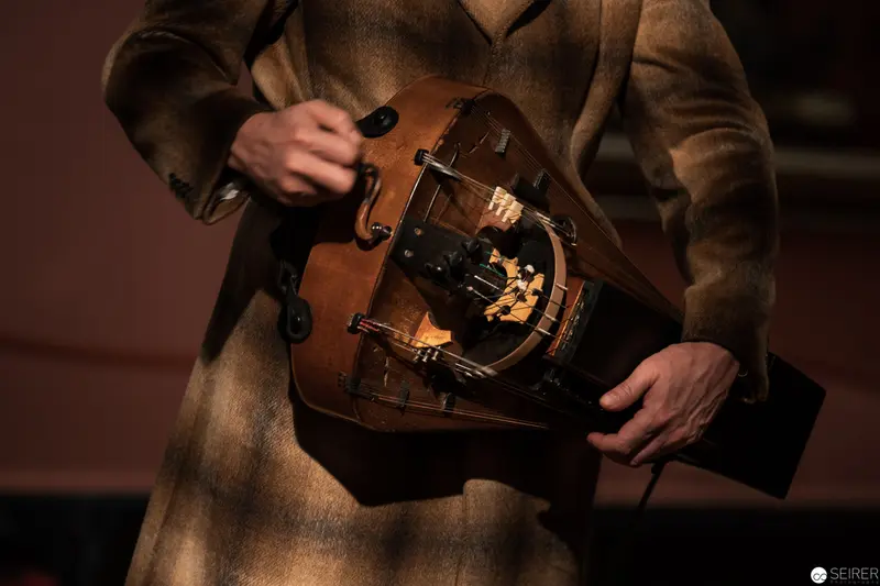 Hurdy-Gurdy Performance in Warm Sepia-Toned Traditional Attire