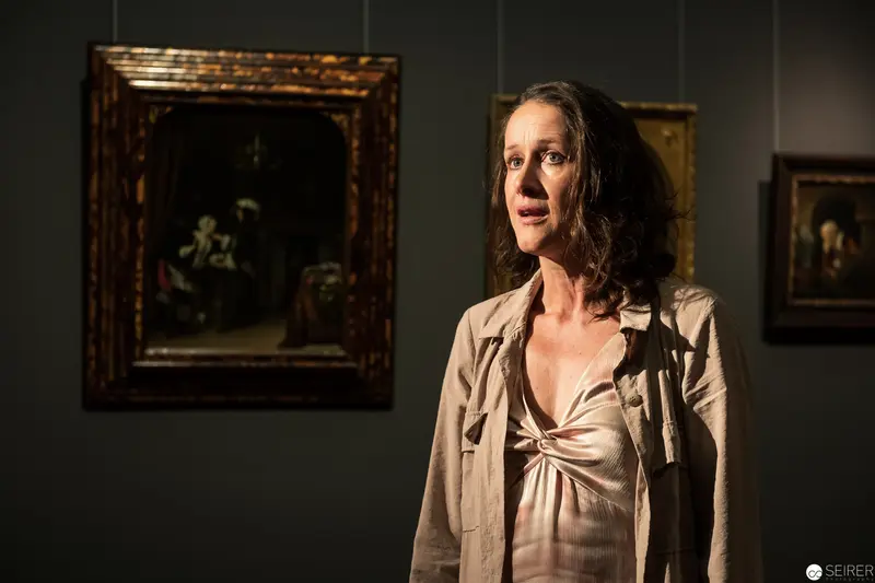 Contemplative Pose in Art Gallery with Dramatic Side Lighting