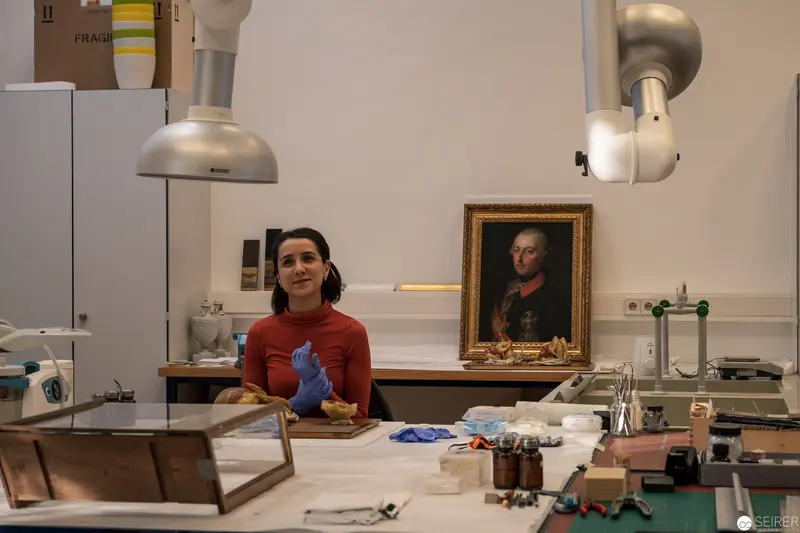 Conservator in Laboratory with Historical Portrait of Nobleman