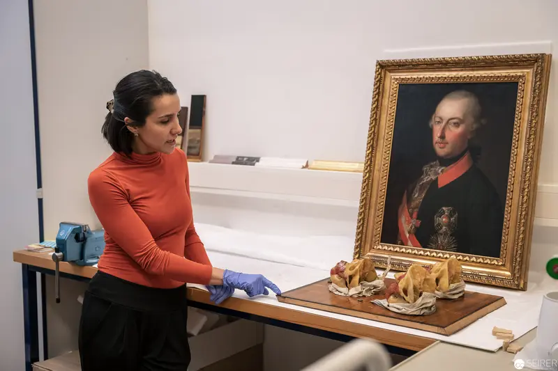Museum Conservator Examining Historical Portrait with Protective Gloves