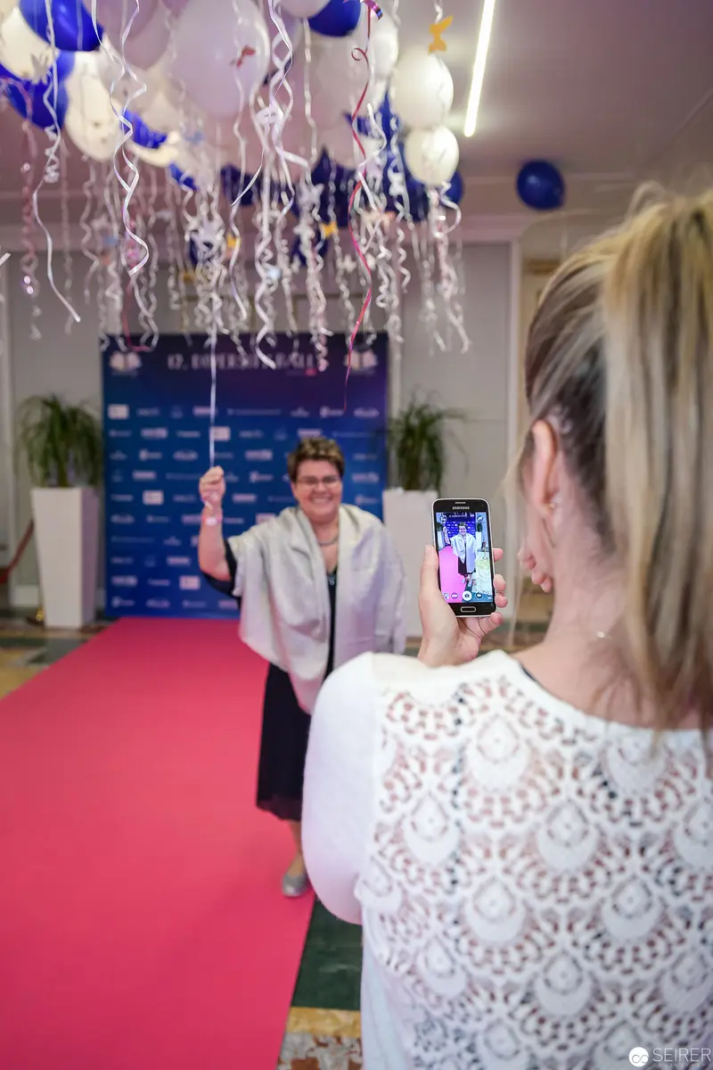 Person on Red Carpet Photographed with Smartphone at Celebratory Event