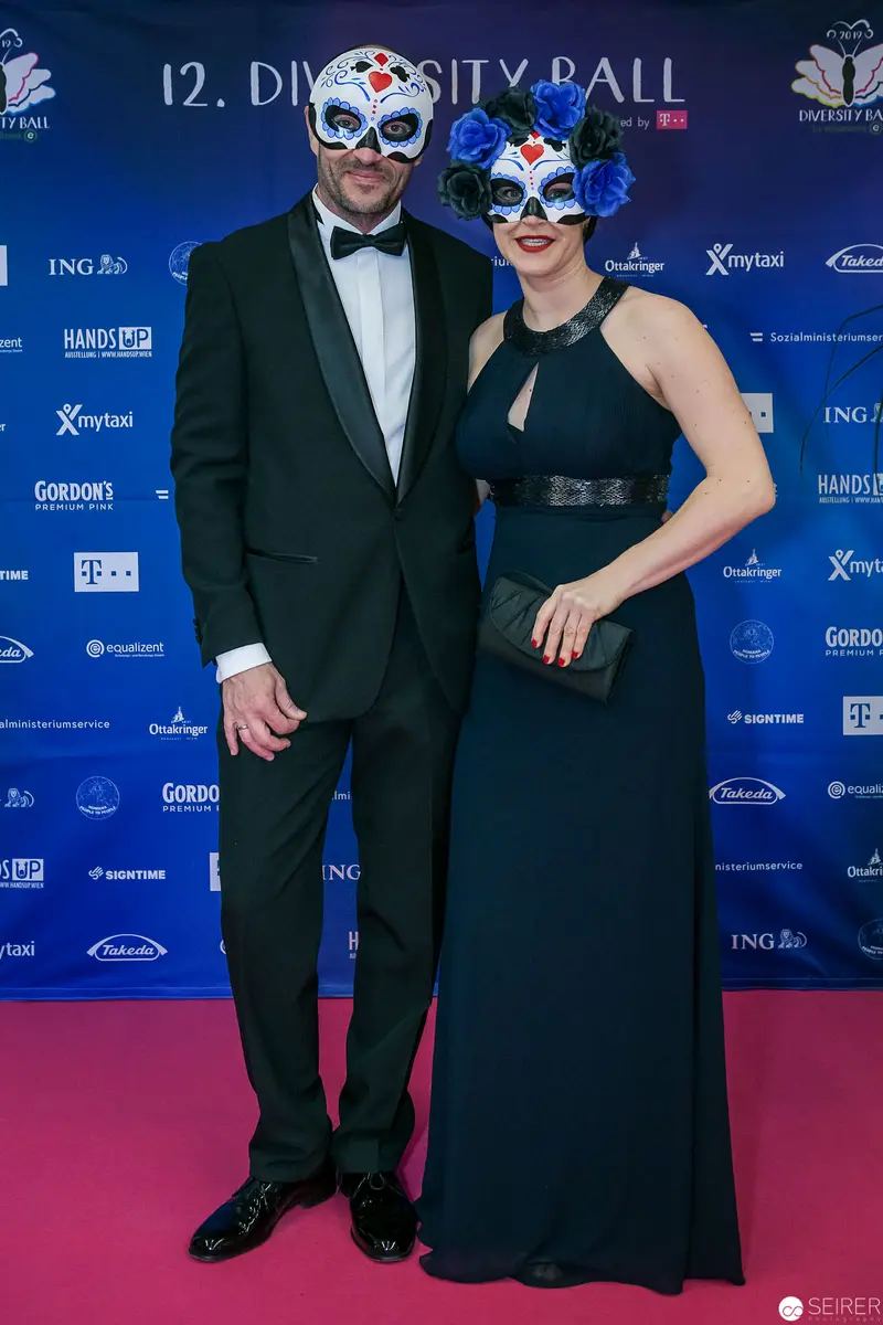 Masked Couple Posing at 12th Diversity Ball in Formal Evening Attire
