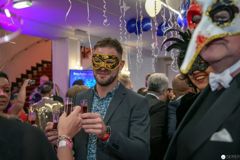 Masked Revelers at Masquerade Party Holding Champagne Glasses