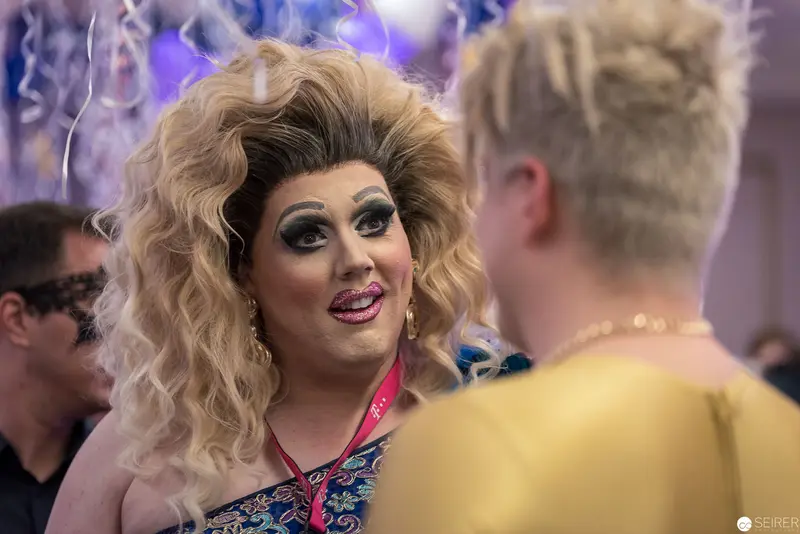Glamorous Drag Performance at Social Event with Vibrant Styling and Interaction