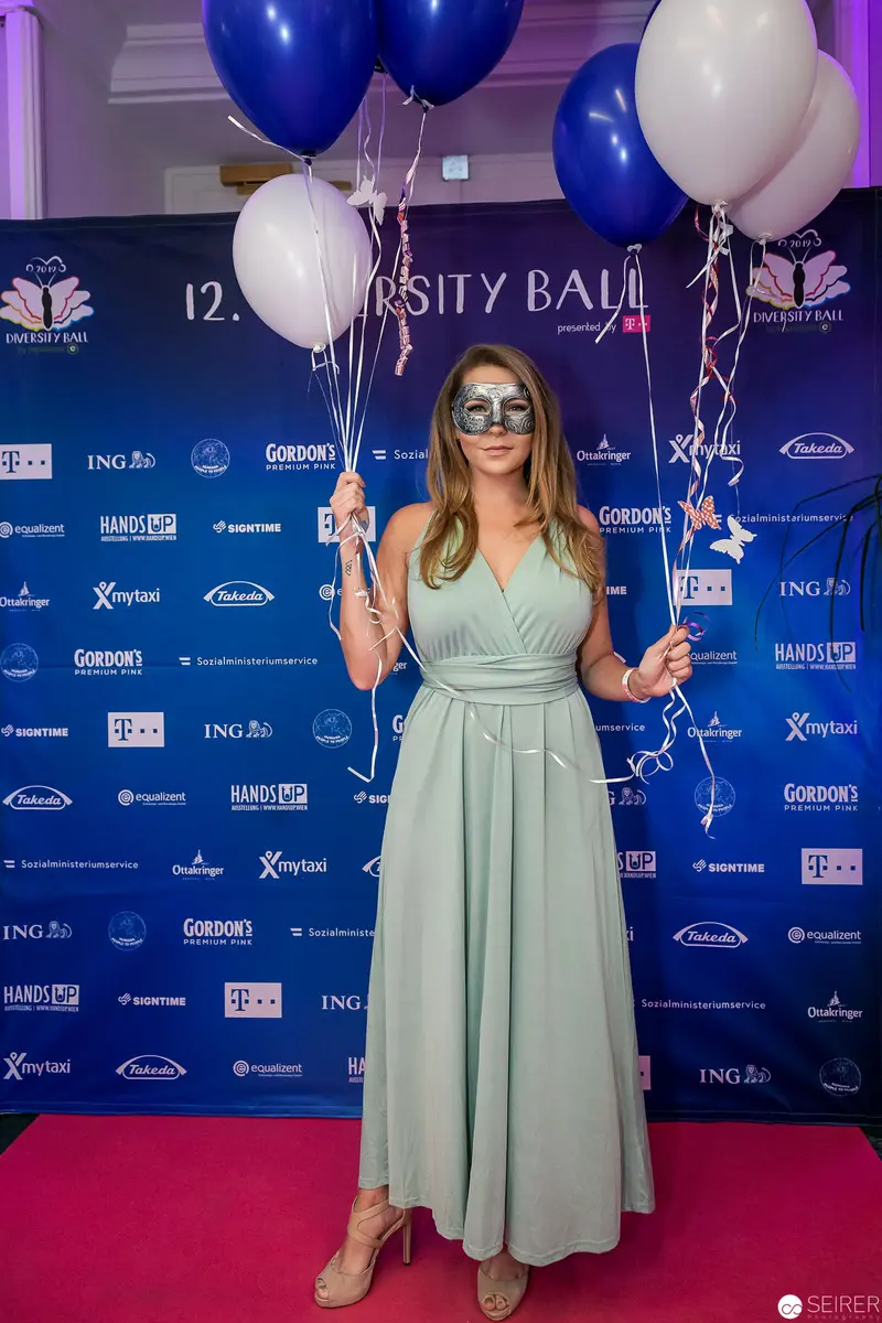 Woman in Mint Green Dress at University Ball with Blue and White Balloons