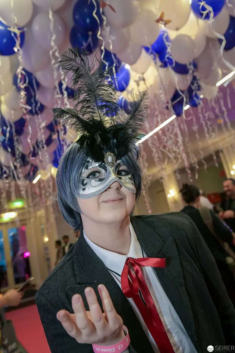 Masquerade Ball Participant in Ornate Feathered Mask and Theatrical Costume
