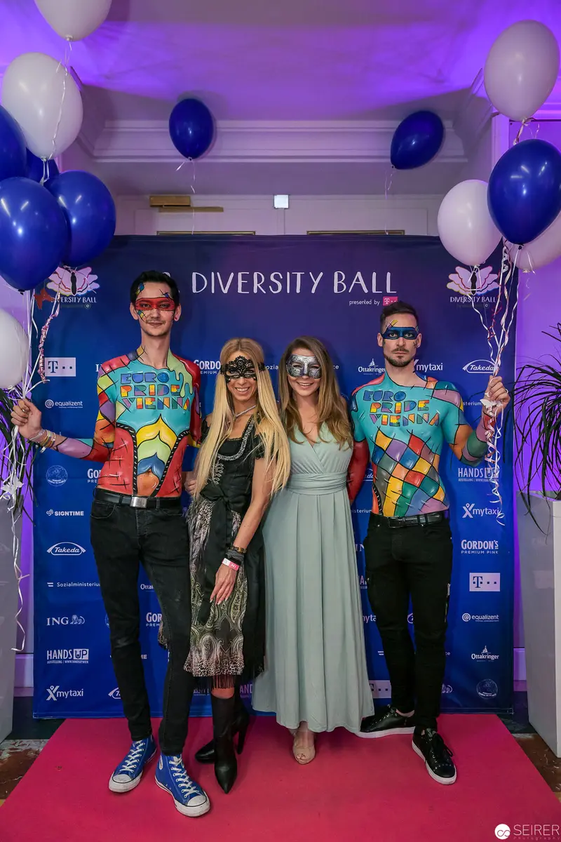 Four Attendees Pose at Diversity Ball Event with Purple and Blue Balloons