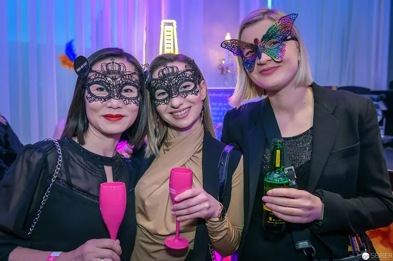 Three Women in Decorative Masquerade Masks at Evening Social Event