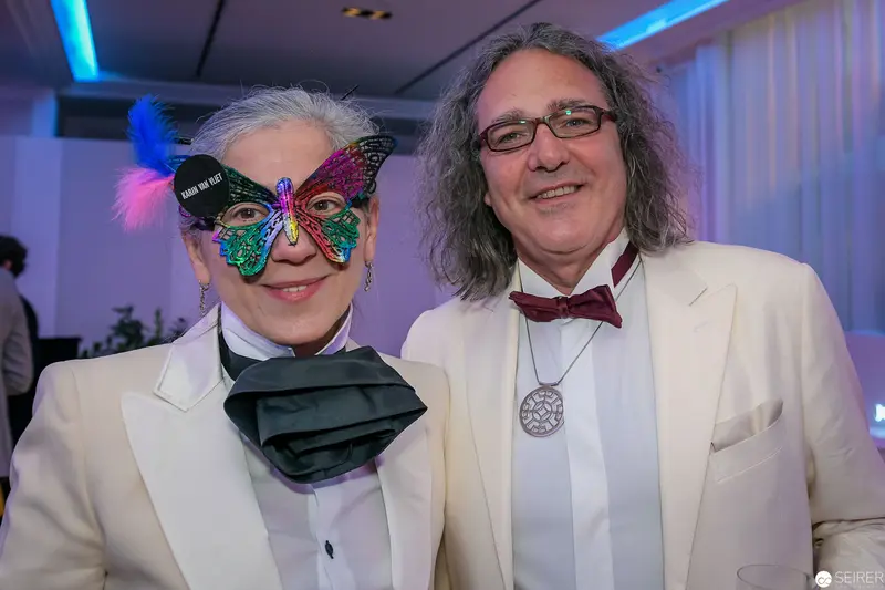 Elegant Masquerade Couple in White Suits and Decorative Mask