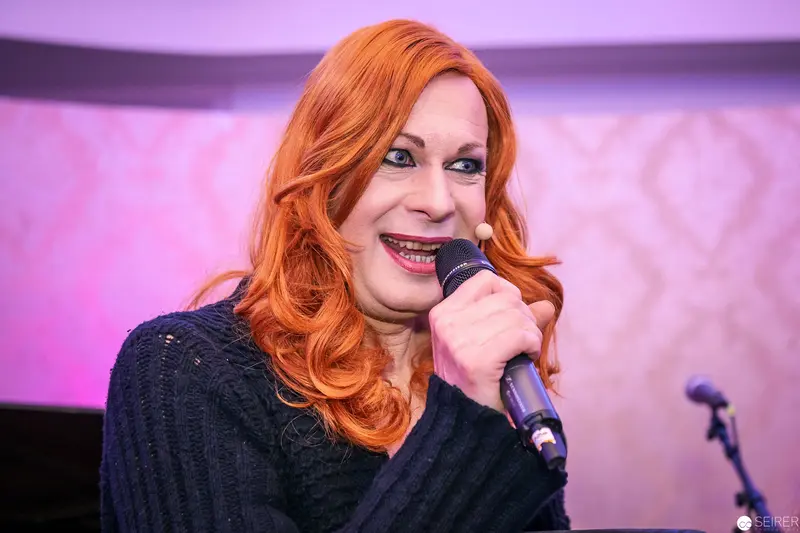 Vibrant Performer with Microphone Under Pink Stage Lighting