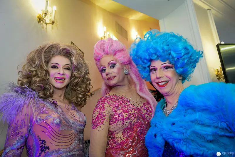 Three Drag Performers in Vibrant Wigs and Elaborate Costumed Glamour