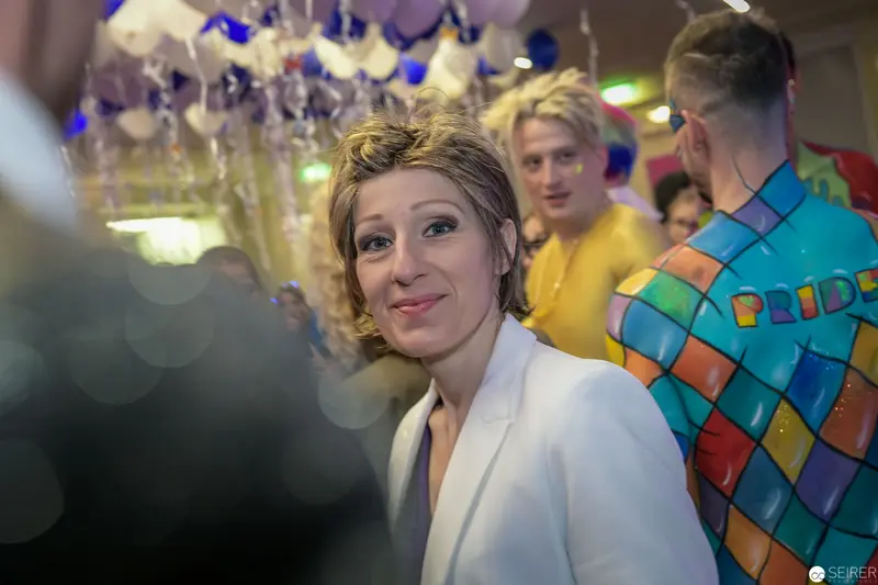 White Jacket at Pride Event with Blue and Purple Balloons