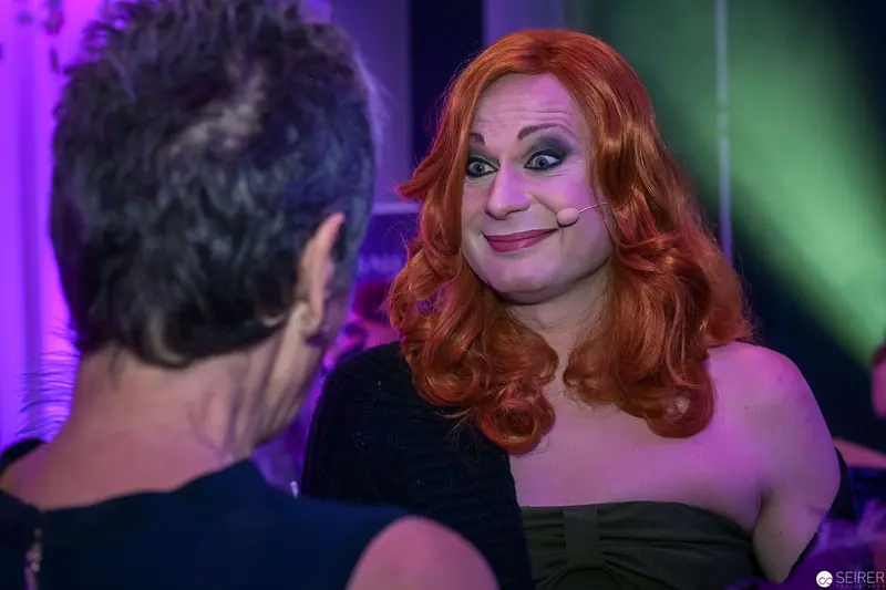 Vibrant Drag Performance at Nightclub with Colorful Stage Lighting