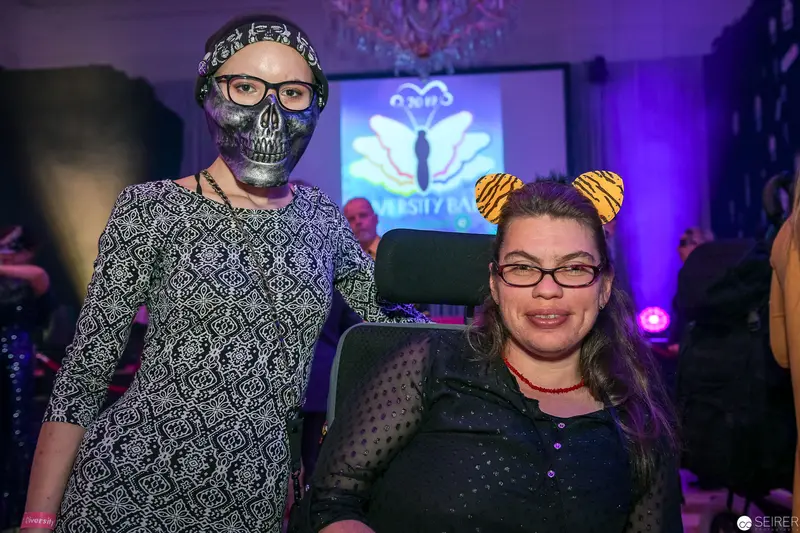 Costumed Attendees at Themed Event with Skull Mask and Tiger Ears