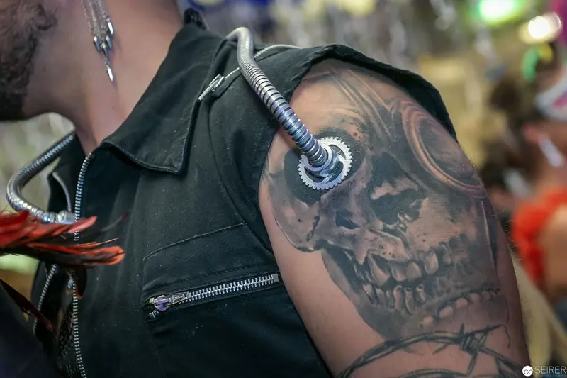 Cyberpunk Skull Tattoo on Leather-Clad Shoulder with Mechanical Gear