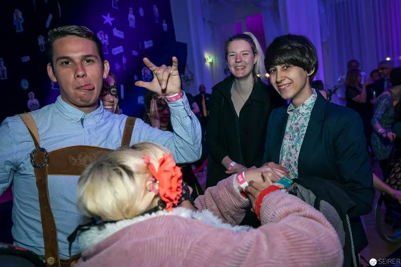 Nighttime Social Event with Diverse Young People in Atmospheric Purple Lighting