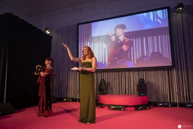Two Performers on Stage with Large Video Projection Backdrop