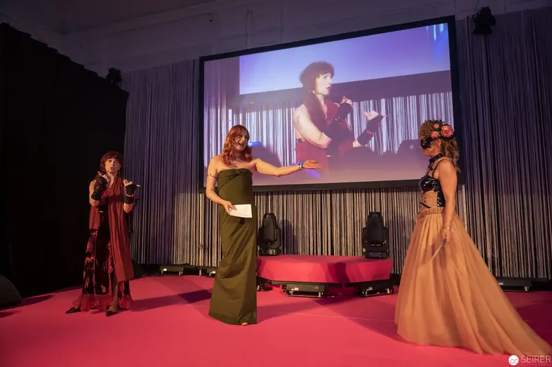 Women on Stage at Formal Event with Large Projection Screen Backdrop