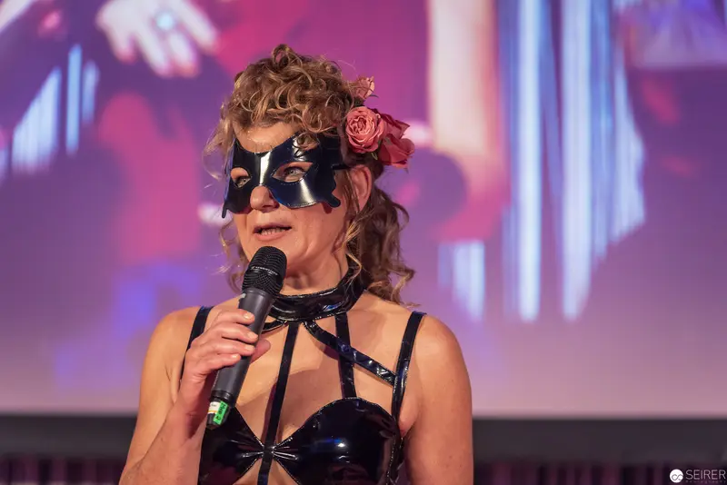 Masked Performer with Floral Accent Delivers Dramatic Stage Performance
