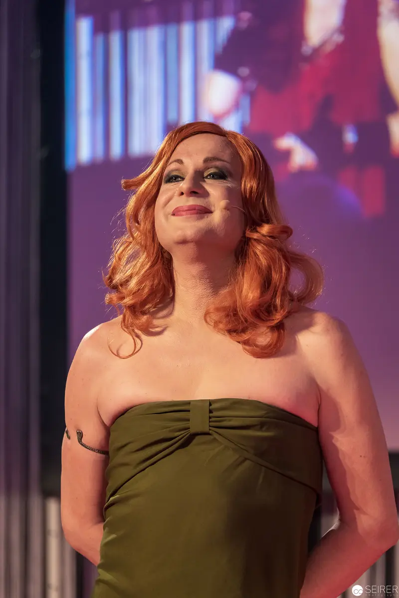 Performer in Olive Green Strapless Dress on Dramatic Staged Setting
