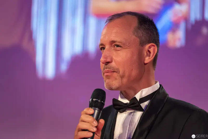 Master of Ceremonies in Black Tie Delivers Keynote with Microphone