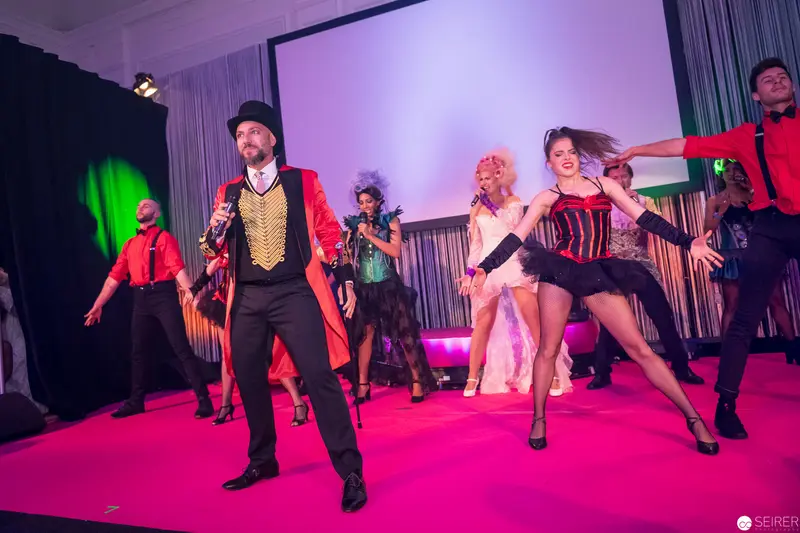 Theatrical Performers on Vibrant Pink Stage in Dynamic Cabaret Performance
