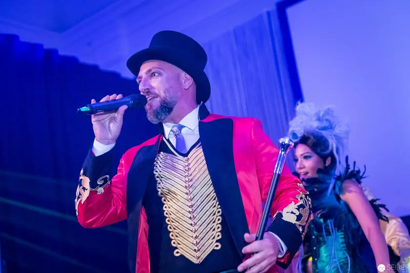 Ringmaster Performer in Red Jacket Delivering Theatrical Musical Performance