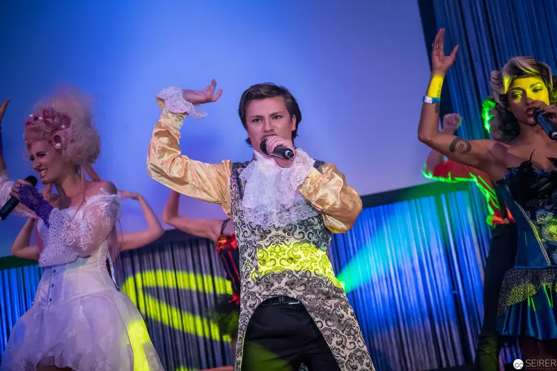 Flamboyant Musical Performance with Costumed Performers on Vibrant Stage