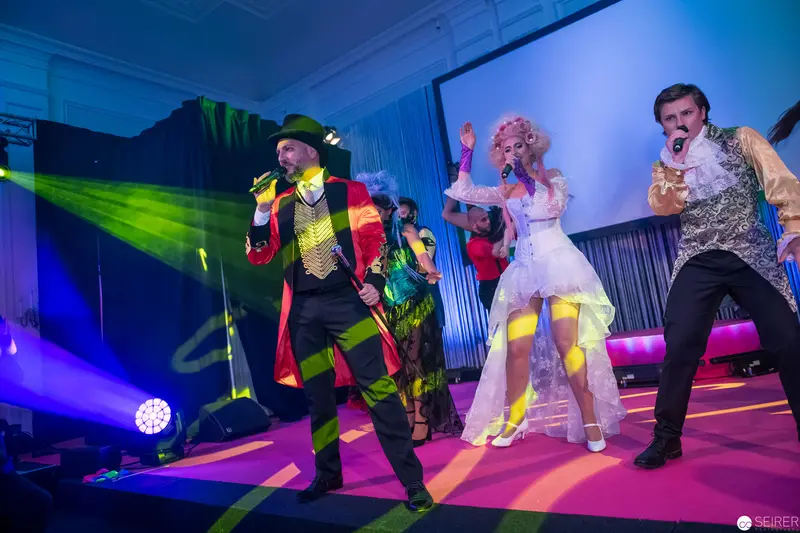 Theatrical Stage Performance with Colorful Performers in Vibrant Costume and Lighting
