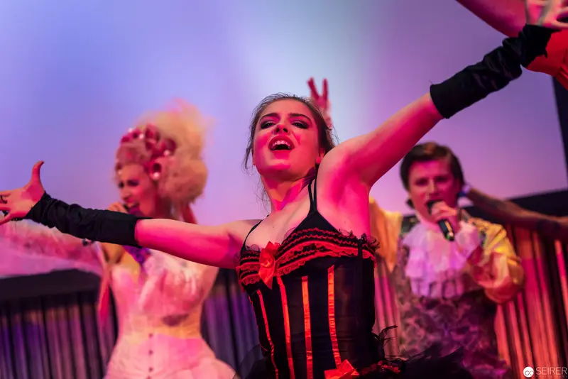 Theatrical Performance with Dramatic Performers in Vibrant Stage Lighting