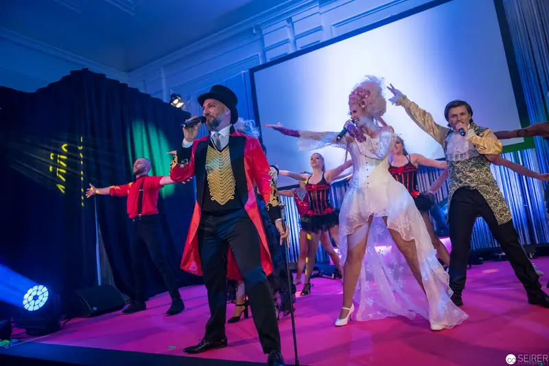 Theatrical Performance Ensemble in Vibrant Ringmaster and White Costume Staging