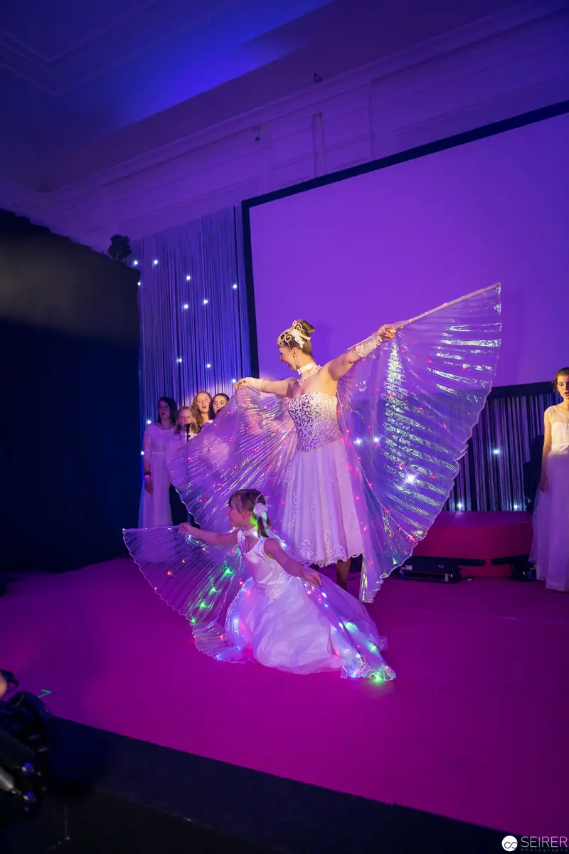 Luminescent Dancers in Ethereal Purple Performance Stage Composition