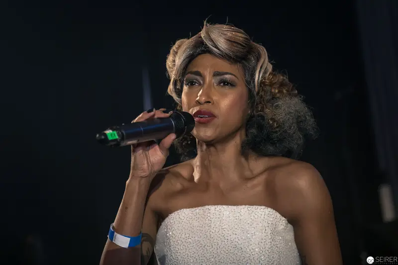 Elegant Performance: Singer in Strapless White Dress at Microphone