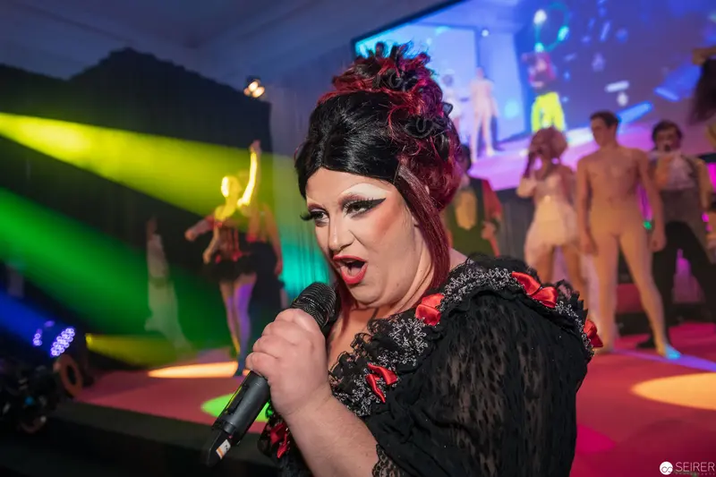 Dramatic Drag Performance with Vibrant Stage Lighting and Performers