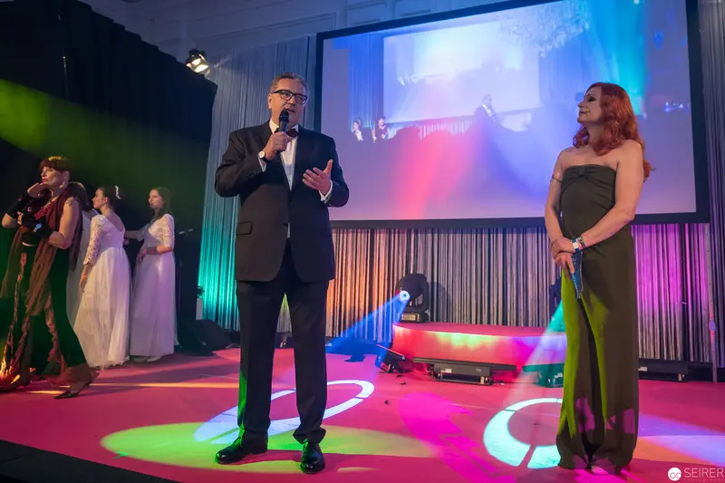 Multicolored Stage Performance with Host and Singer in Elegant Evening Attire