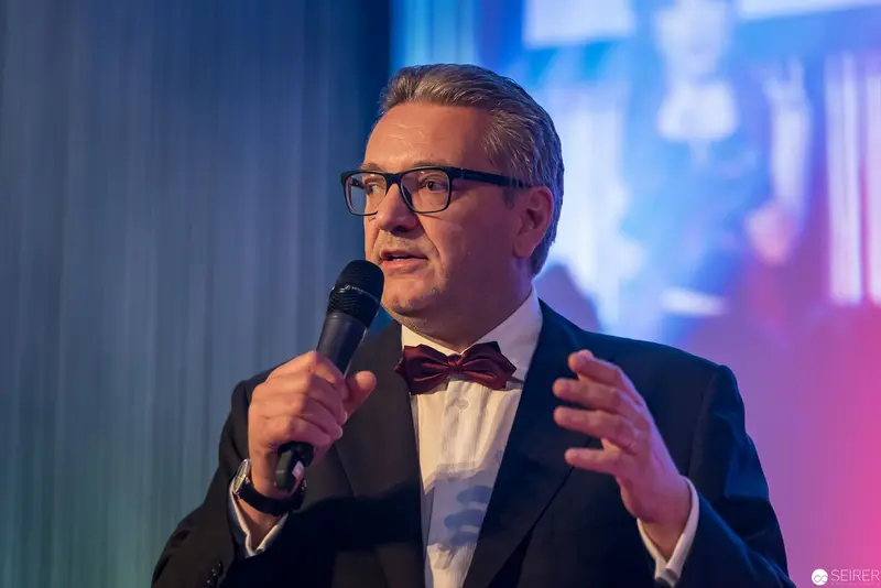 Distinguished Speaker Delivering Presentation with Microphone in Formal Evening Attire