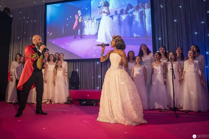 Choral Performance with Soloist in White Gown and Dramatic Red Conductor