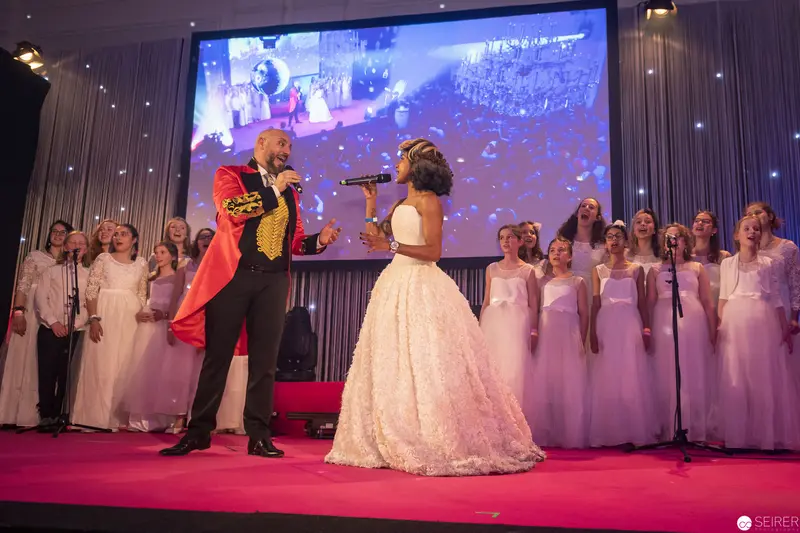 Theatrical Performance with Soloist and Choir on Crimson Stage