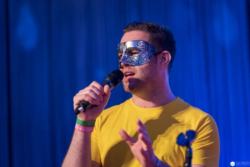 Masked Performer in Yellow Shirt Delivers Passionate Vocal Performance