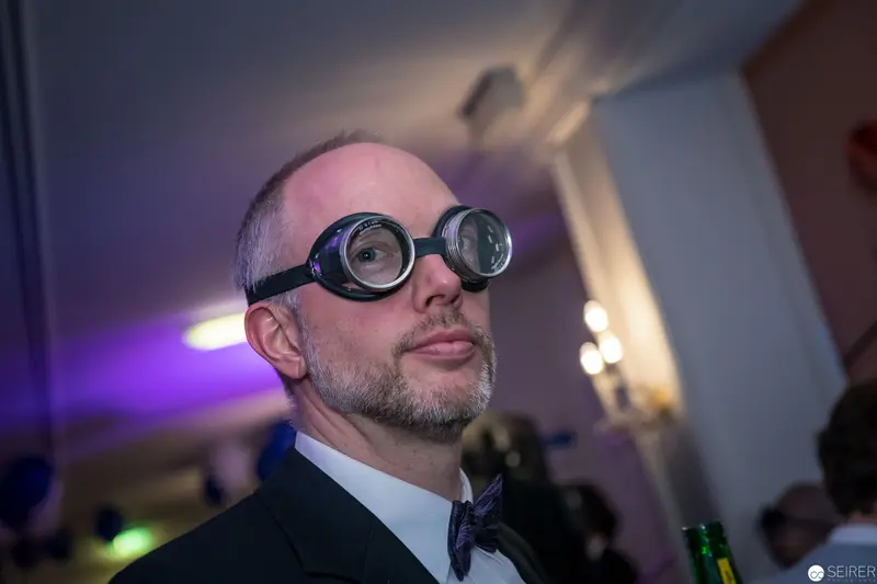 Bespectacled Gentleman in Vintage Goggles at Formal Evening Event