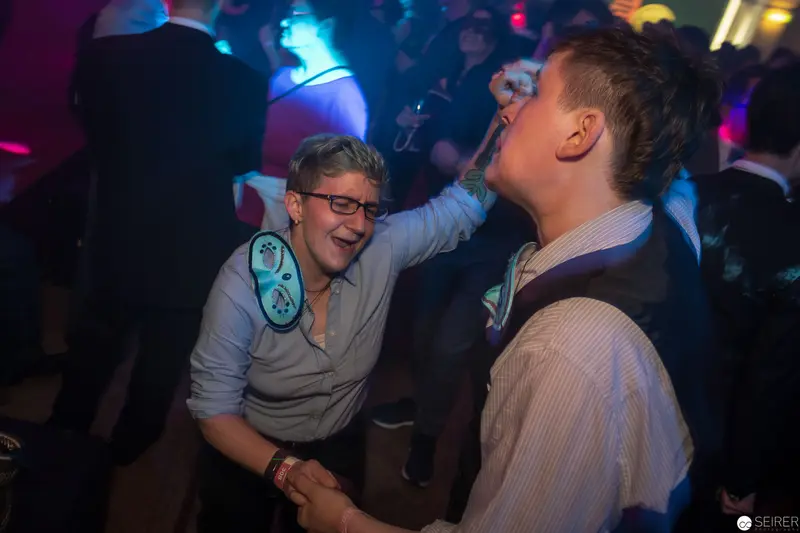 Nightclub Interaction: Two Men in Vibrant Dance Floor Lighting