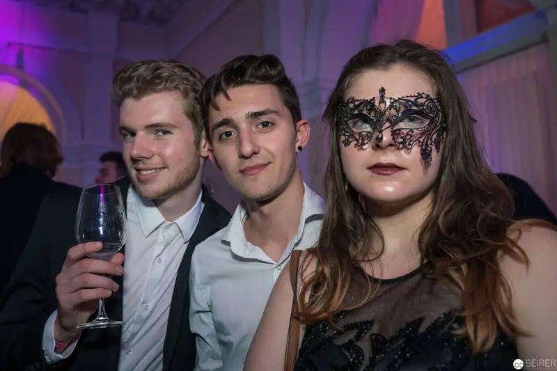 Masked Revelers at Formal Evening Event with Decorative Masquerade Aesthetic