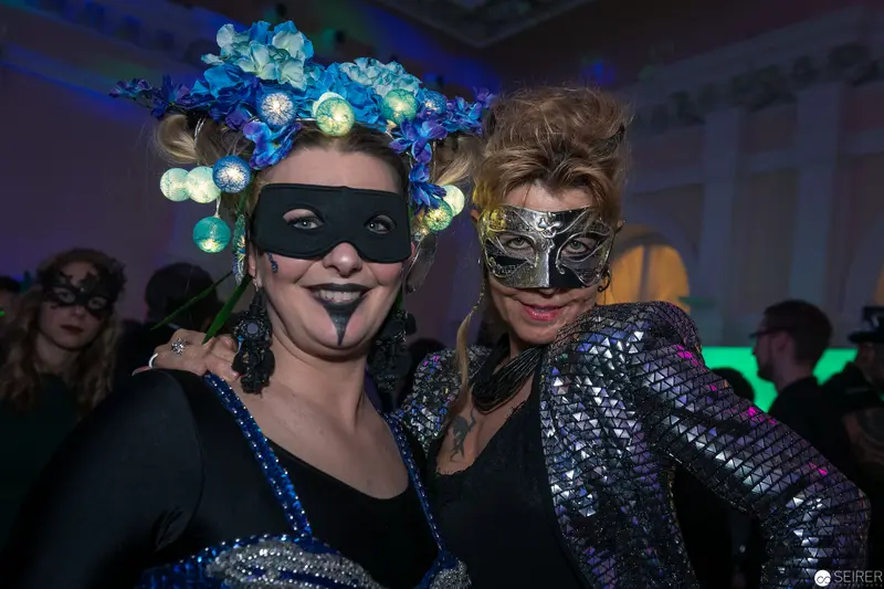 Masked Revelers in Ornate Costume at Nocturnal Masquerade Ball