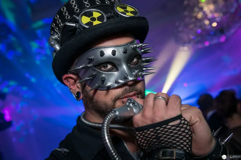 Cyberpunk Performance Artist in Spiked Mask and Nuclear-Themed Headgear