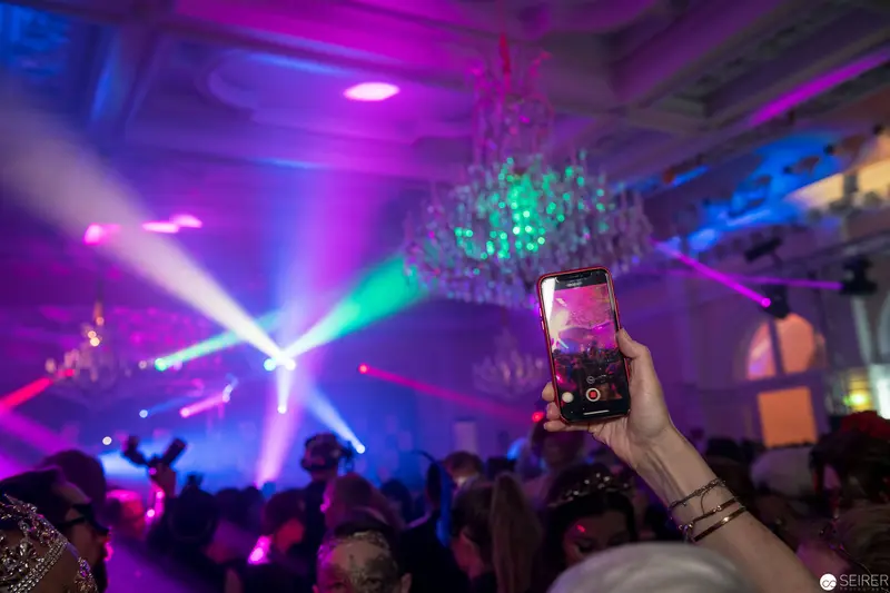 Smartphone Raised During Vibrant Nightclub Light Show with Dynamic Laser Beams
