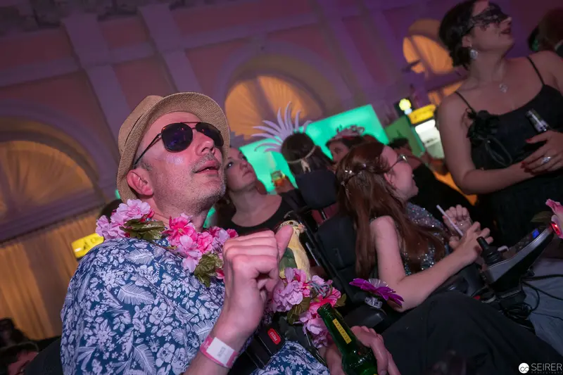 Festive Party Scene with Sunglassed Man in Floral Shirt and Lei