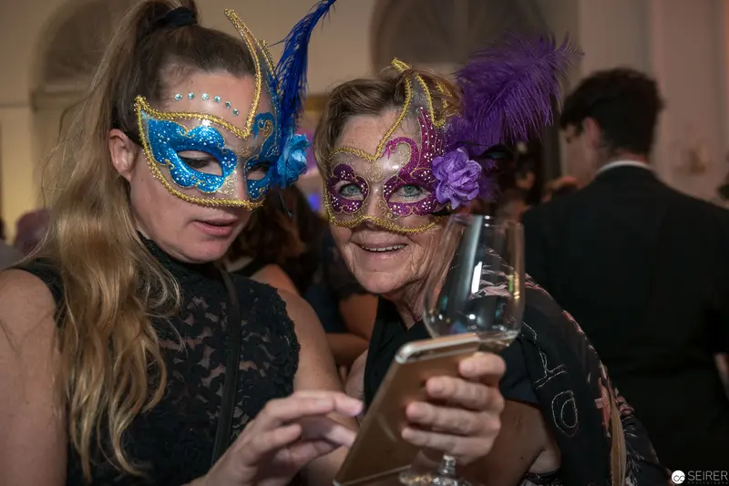 Masked Companions Sharing Festive Moment at Masquerade Ball