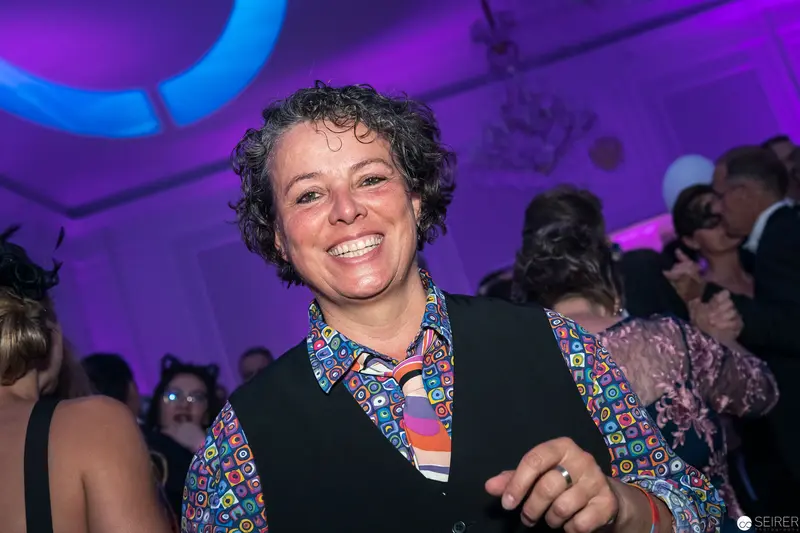 Joyful Guest at Festive Event in Purple-Lit Venue