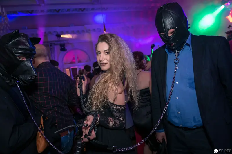 Staged Encounter at Nightclub with Chained Performers in Leather and Mesh