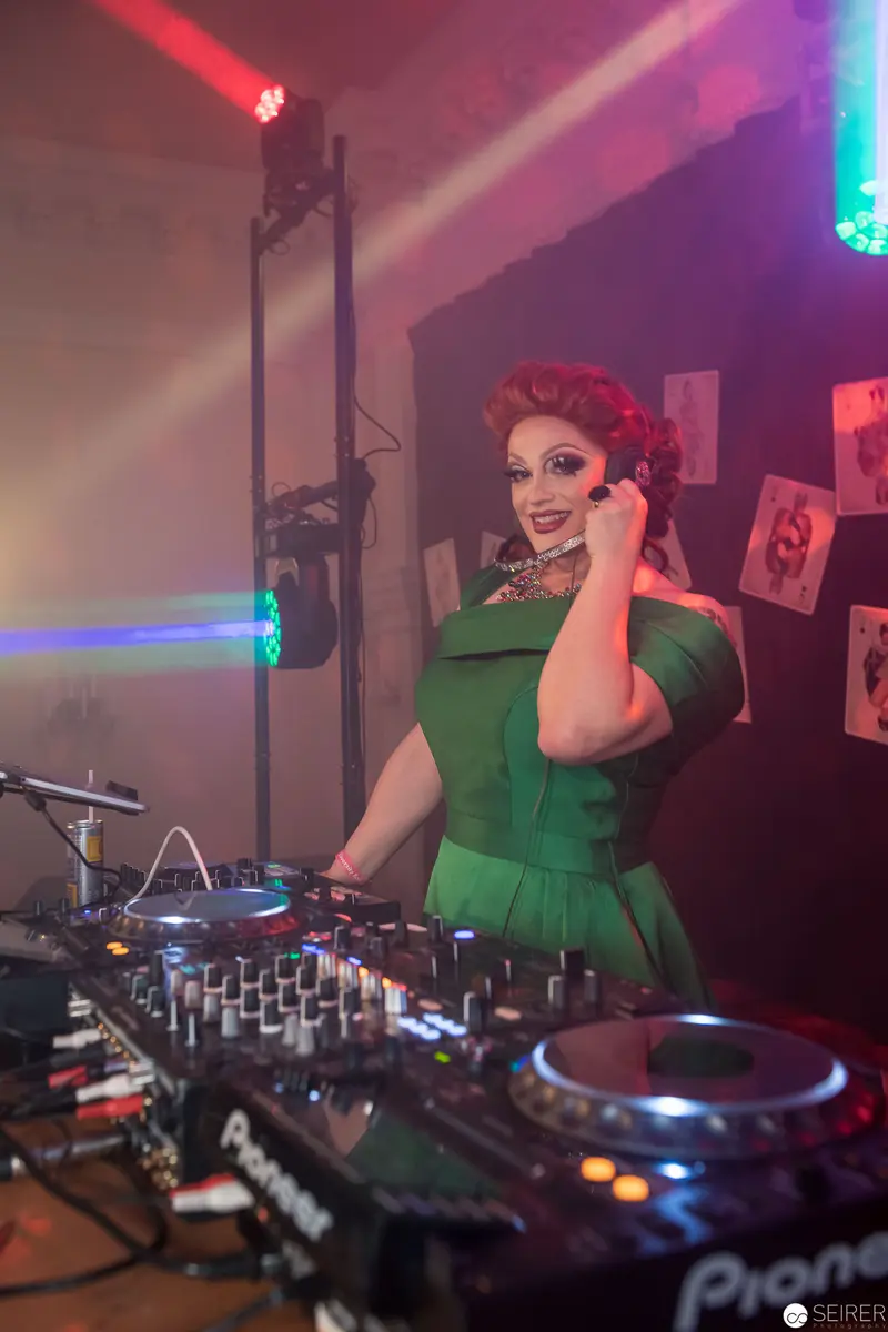 Vintage-Styled DJ in Green Dress Performing at Nightclub Venue